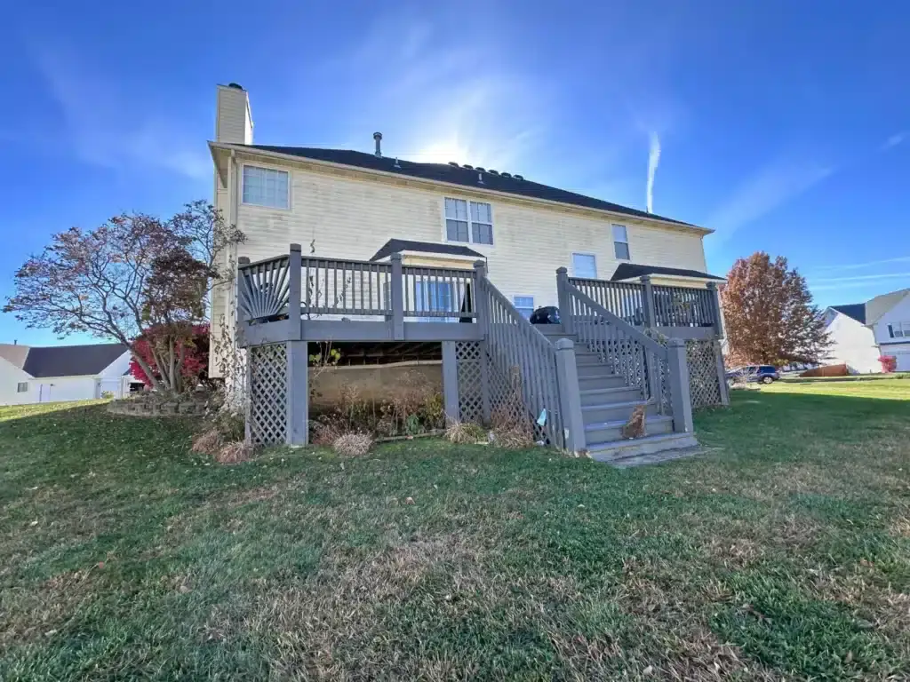 The back of a yellow house that we bought fast for cash